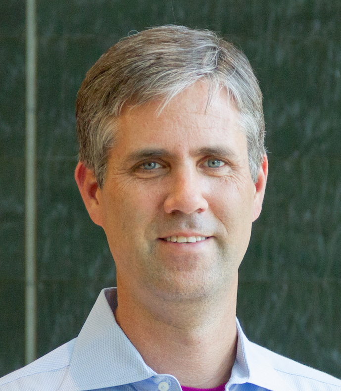Photo of Michael Swift. He has short gray hair and is wearing a blue button down shirt.